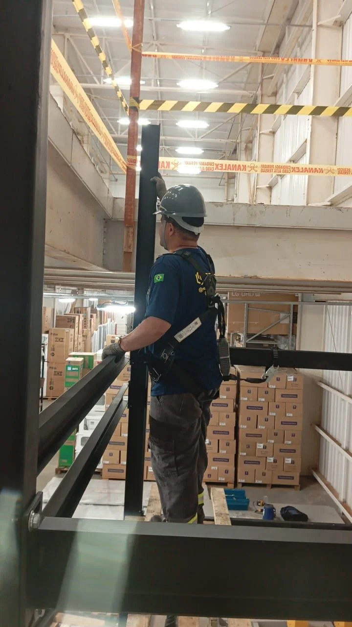 Técnico Select com cinto de segurança em montagem de estrutura