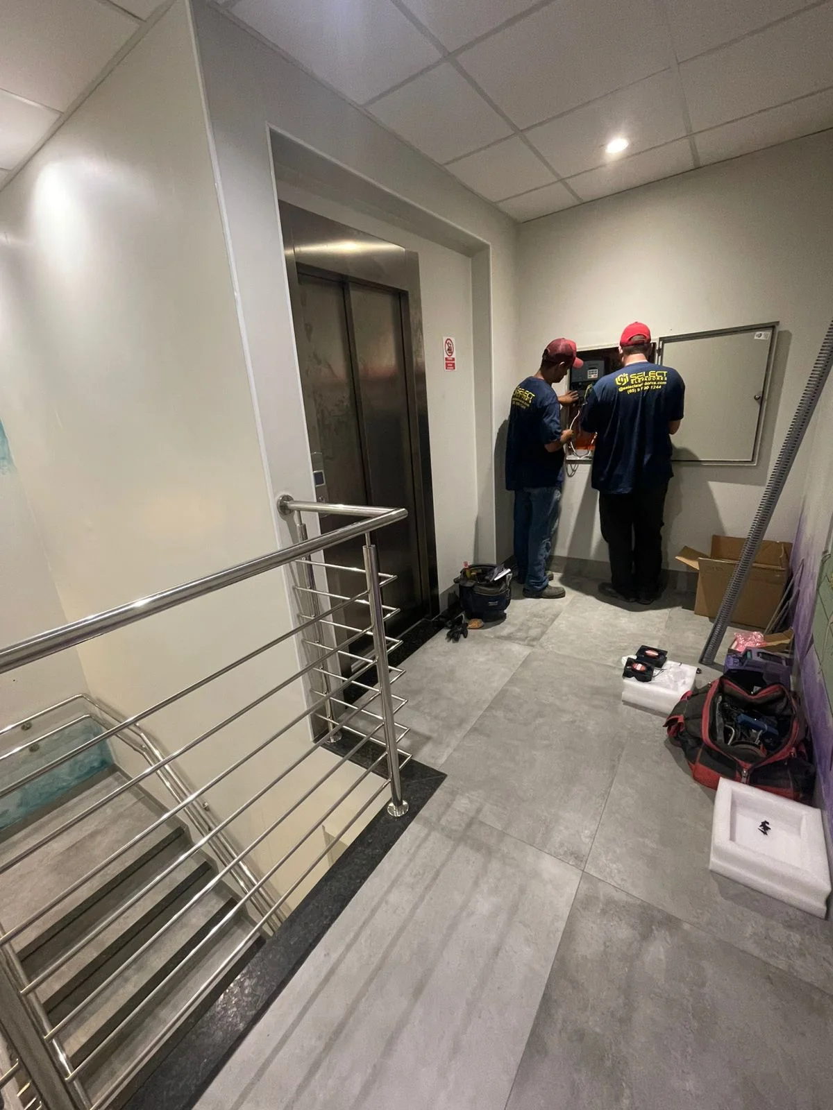 Dois técnicos Select em manutenção de elevador