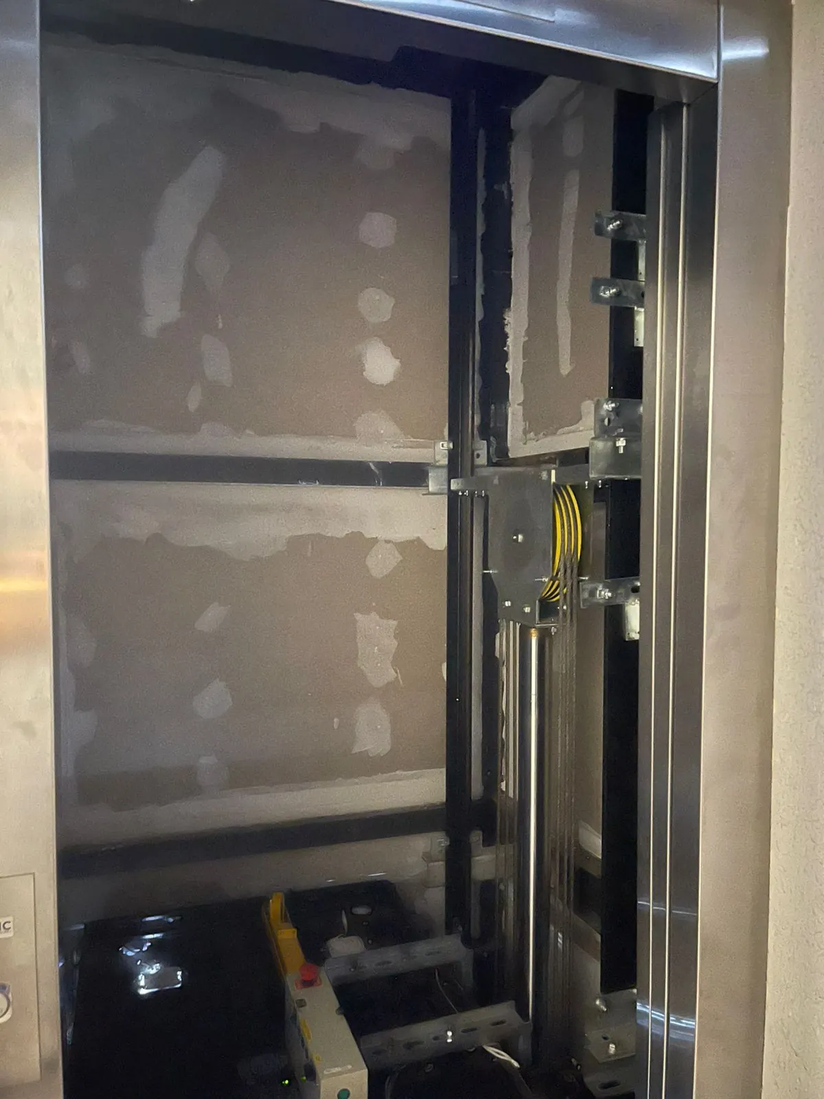 Poço de elevador com mecanismo aparente durante modernização